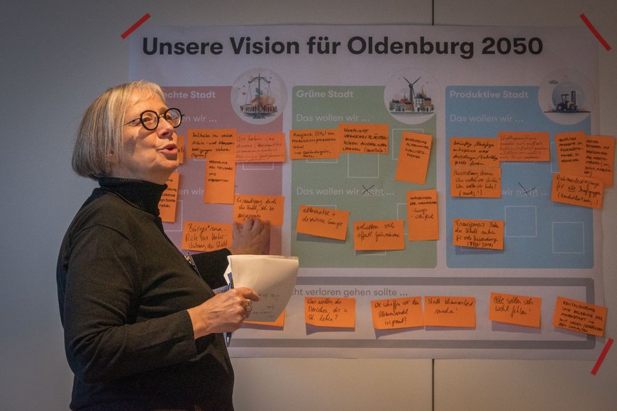 Das Plakat einer Arbeitsgruppe wird erläutert. Foto: Stadt Oldenburg