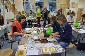 Vertiefte Teilnehmende des Nachmittagsworkshops beim Färben mit Pflanzenfarben. Stadt Oldenburg.
