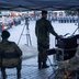 Vorschau: Drei Soldaten sitzen unter einem Zelt und sehen sich den Festakt an. Foto: Sascha Stüber