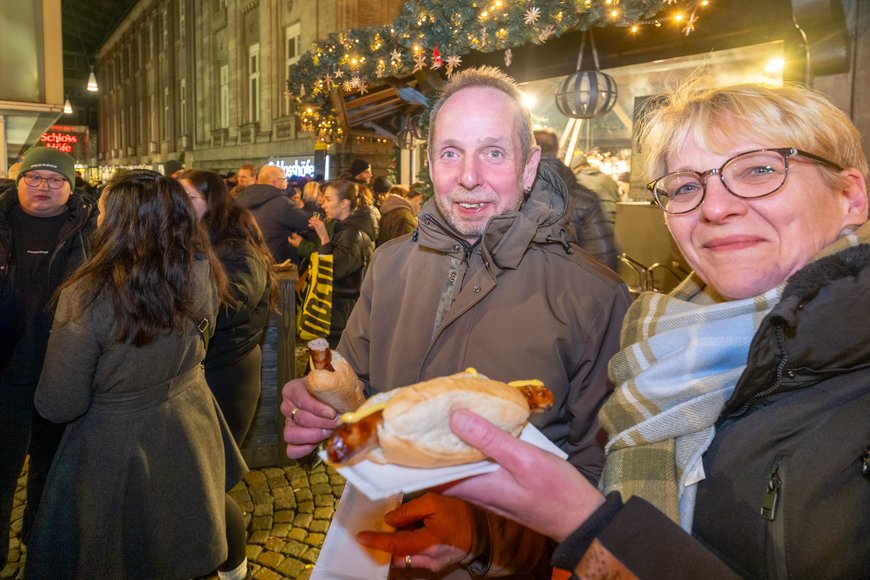 Sascha Stüber Besuchende mit Bratwurst auf dem Lamberti-Markt 2025. Foto: Sascha Stüber