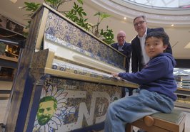 Der elfjährige Dominic Chen spielte als Erster auf dem Piano in den Schlosshöfen. Oberbürgermeister Jürgen Krogmann und Center-Manager Stefan Tenk (links) waren begeistert. Konterfei und Unterschrift von Klaas Heufer-Umlauf zieren das Instrument. Foto: Sascha Stüber 