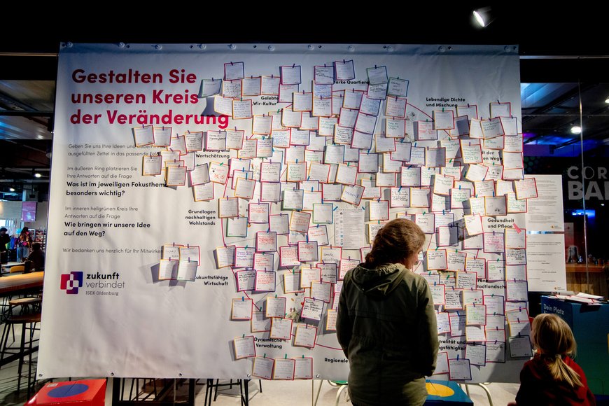 Ein kleines Mädchen bewundert die Leinwand mit dem „Kreis der Veränderung“. Foto: Hauke-Christian Dittrich