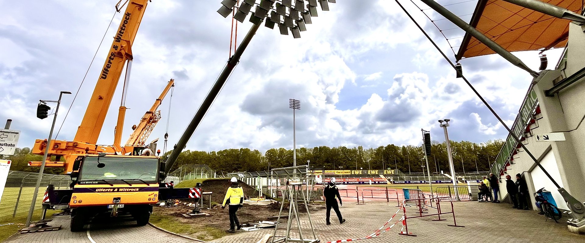 Am Haken: In Millimeterarbeit wurden die schweren Flutlichtmasten auf die vorbereiteten Fundamente gehoben.  Foto: Stadt Oldenburg