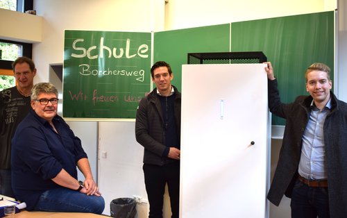 Freuten sich über die ersten Luftfiltergeräte in der Schule Borchersweg: (von links) Konrektor Carsten Perkuhn, Schulleiter Stefan Völkel, Michèl Storl (Firma Johnson) und Steffen Schmidt (Amt für Schule und Bildung). Foto: Stadt Oldenburg