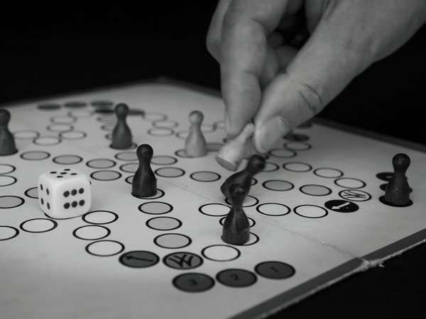 Eine Hand, die eine Figur auf einem Mensch-ärgere-dich-nicht-Spiel bewegt. Foto: Margit Sauer Eine Hand, die eine Figur auf einem Mensch-ärgere-dich-nicht-Spiel bewegt. Foto: Margit Sauer