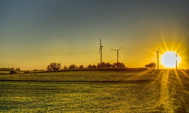 Ein Feld mit Windrädern im Sonnenuntergang. Foto: Markus Distelrath/Pixabay