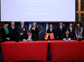 Oberbürgermeister Krogmann unterzeichnet eine Vereinbarung zwischen dem Sino-German Ecopark und der Stadt Oldenburg, im Hintergrund stehen Mitglieder der Delegation. Foto: Stadt Oldenburg