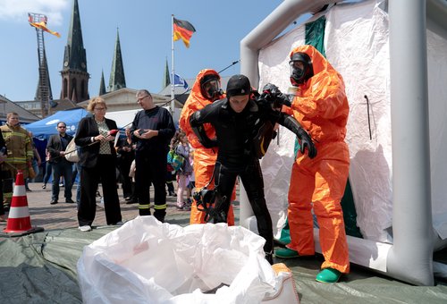 Die Feuerwehr Oldenburg demonstrierte für die niedersächsische Innenministerin Daniela Behrens (3. von links), wie die Einsatzkräfte mit kontaminierter Ausrüstung umgehen. Foto: Izabela Mittwollen 