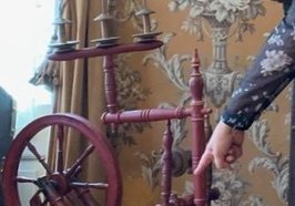 Kunstvermittlerin Geraldine Dudek zeigt auf ein Spinnrad. Foto: Stadt Oldenburg