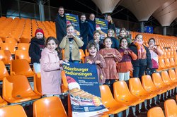 (hinten, v. l.) Marco Harms (Sportbüro), Dimitri Melnik (Leiter der Musikschule), Christian Köhler (Vorsitzender der Regionalen Stiftung der LzO) und Chantal Cordes (Kinderchor) sowie einige der Chorkinder. Foto: Sasch Freuen sich auf das Stadionsingen: (hinten, von links) Marco Harms (Sportbüro der Stadt Oldenburg), Dimitri Melnik (Leiter der Musikschule), Christian Köhler (Vorsitzender der Regionalen Stiftung der LzO) und Chantal Cordes (Kinderchor-Leiterin) sowie einige der Chorkinder. Foto: Sascha Stüber