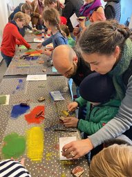 Erwachsene unterstützen Kinder beim Basteln. Foto: Buchkinder Oldenburg