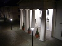 Beleuchtete Säulen vor der Schlosswache im Dunkeln.
