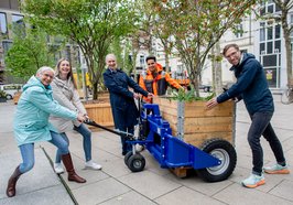 Silke Fennemann (Geschäftsführerin OTM), Melanie Jauken (Leitung Veranstaltungsmanagement OTM), Tanja Piening (Leitung Fachdienst Stadtgrün – Planung und Neubau), Gabriel Kaya (Fachdienst Stadtgrünpflege und Friedhöfe) und Guido Mußmann (Leitung Fachdienst Straßenunterhaltung) ziehen gemeinsam einen beflanzten Kübel mit dem Hubwagen. Foto: OTM