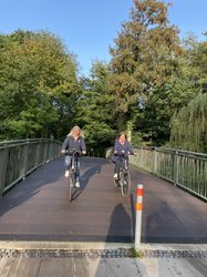 Stadtbaurätin Christine-Petra Schacht (rechts) und Annette Meyers (Leiterin des Amtes für Verkehr und Straßenbau) fahren mit Fahrrädern über die neue Brücke. Foto: Stadt Oldenburg