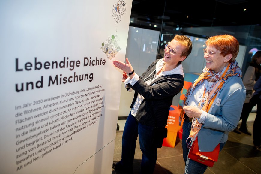 Zwei Mitarbeiterinnen des Stadtplanungsamtes mit bester Laune vor einer Infotafel. Foto: Hauke-Christian Dittrich