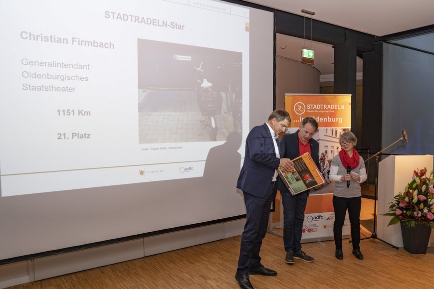 Oberbürgermeister Jürgen Krogmann überreicht einen Preis an den STADTRADELN-Star Christian Firmbach. Foto: Stephan Walzl