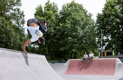 Skateanlage mit einem aktiven und zwei zuschauenden Skatern