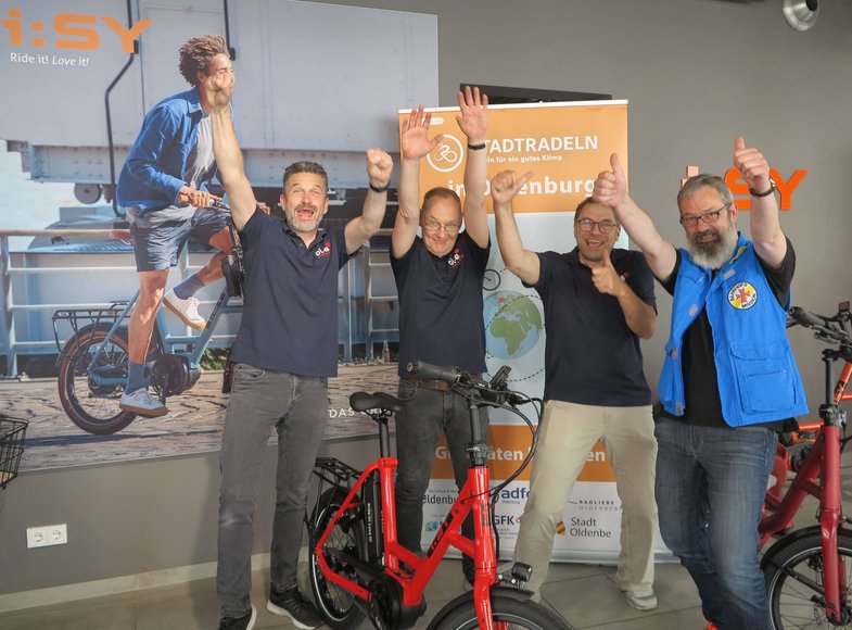 (von rechts): Stephan Mickoleit, Mitarbeiter Bahnhofsmission Oldenburg, Michael Ottens, Inhaber ol-e urban:mobil, und Bernd Heyen und Ingo Wardenburg, Mitarbeiter ol-e urban:mobil, freuen sich auf viele Kilometer für das Erreichen des zweiten Etappenziels. Foto: Stadt Oldenburg