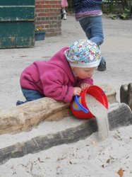Ein Kind spielt mit einem Eimer im Sand. Foto: Stadt Oldenburg