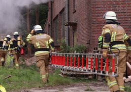 Zwei Kameraden der Feuerwehr tragen eine Leiter zu einem brennenden Haus. Foto: Feuerwehr Oldenburg