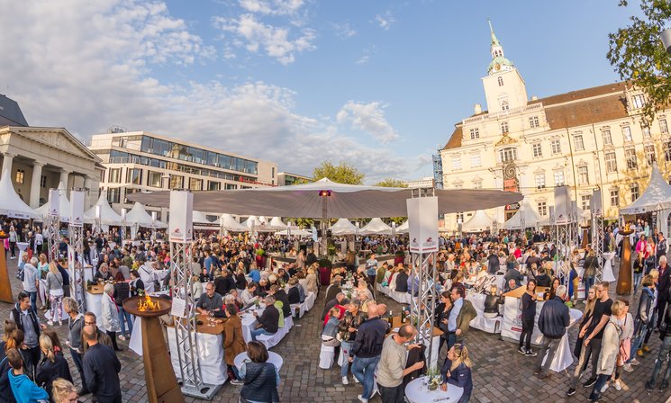 Blick auf die Veranstaltung Kochen am Schloss mit vielen Menschen und dem Schloss im Hintergrund. Foto: Stefan Veismann