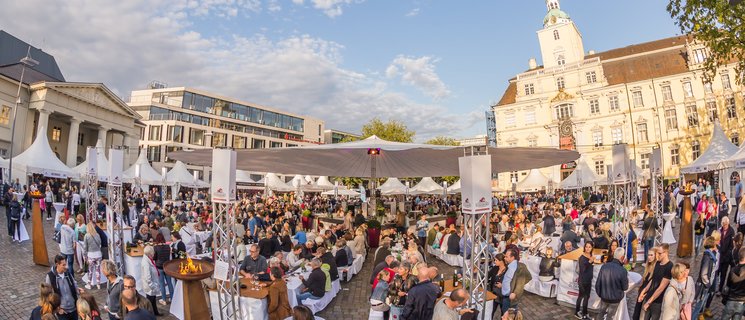 Blick auf die Veranstaltung Kochen am Schloss mit vielen Menschen und dem Schloss im Hintergrund. Foto: Stefan Veismann