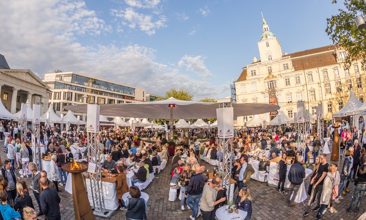 Blick auf die Veranstaltung Kochen am Schloss mit vielen Menschen und dem Schloss im Hintergrund. Foto: Stefan Veismann