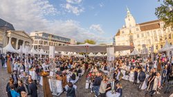 Blick auf die Veranstaltung Kochen am Schloss mit vielen Menschen und dem Schloss im Hintergrund. Foto: Stefan Veismann