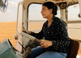 Eine Frau fährt in einem Traktor über ein Feld. Foto: W-film Eine Frau fährt in einem Traktor über ein Feld. Foto: W-film
