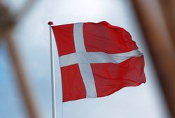 Dänische Flagge weht im Wind. Foto: Sokaeiko/Pixelio.de
