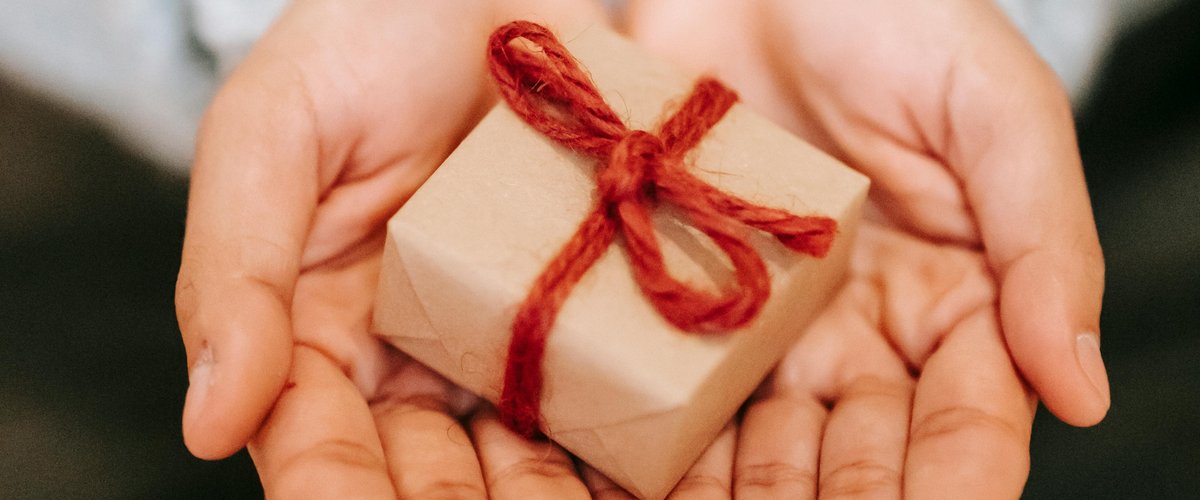 Hände halten ein kleines Geschenk. Foto: Liza Summer/Pexels
