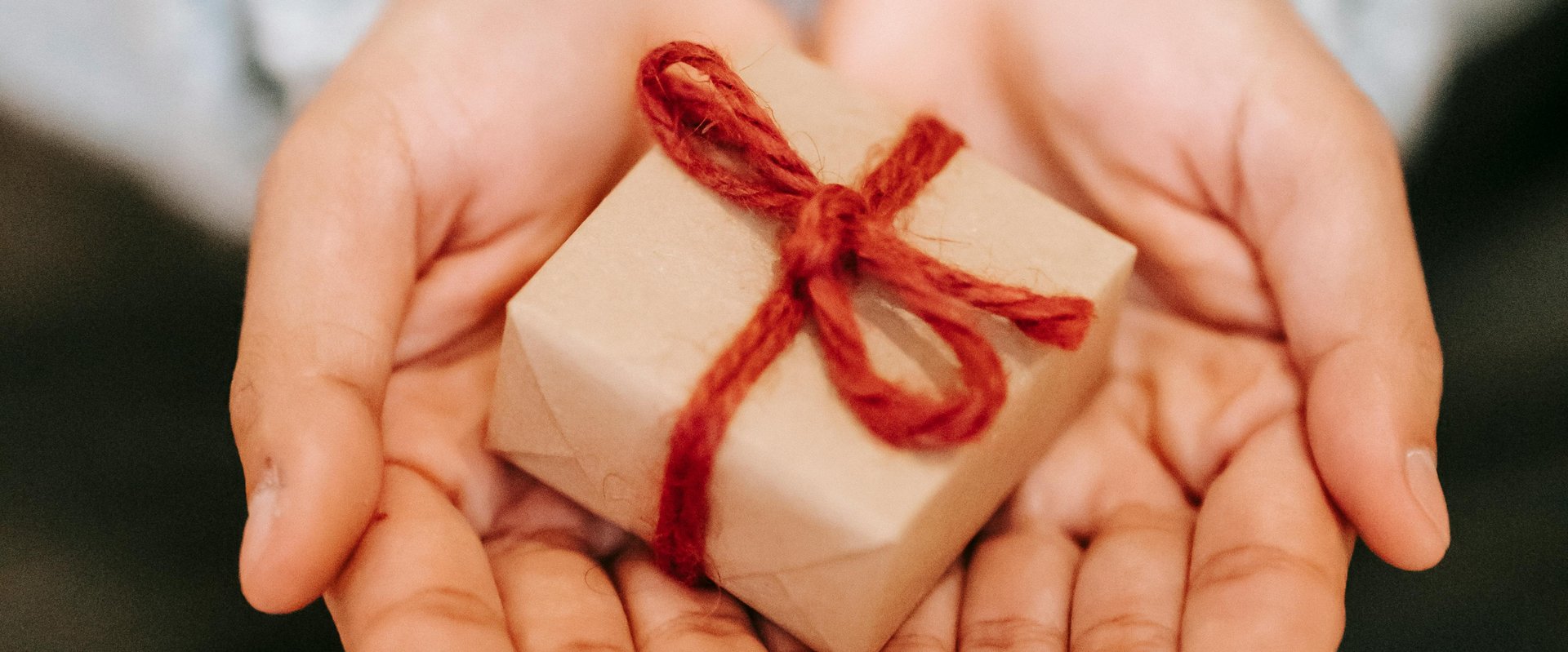 Hände halten ein kleines Geschenk. Foto: Liza Summer/Pexels