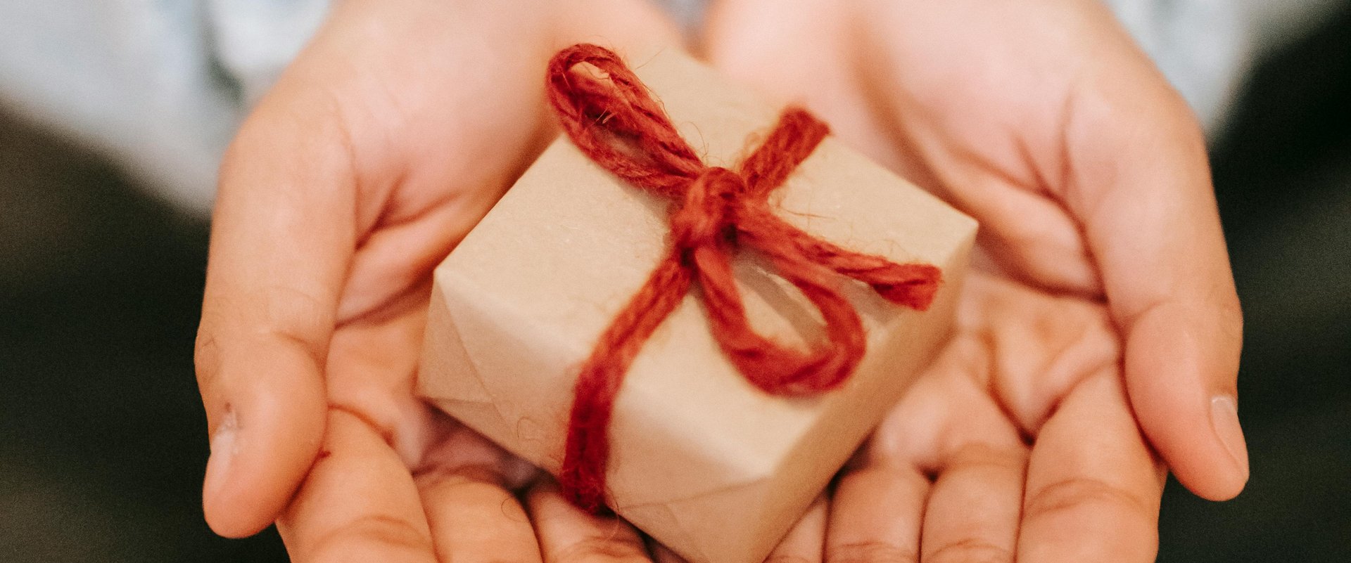 Hände halten ein kleines Geschenk. Foto: Liza Summer/Pexels