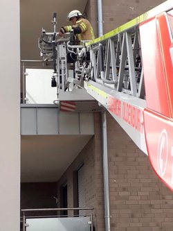 Ausgefahrene Leiter eines Feuerwehrfahrzeugs mit einem Feuerwehrmann an einem Balkon. Foto: Stadt Oldenburg
