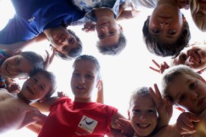 Kinder und Jugendliche stehen in einem Kreis und schauen zur Kamera runter. Foto: S. Hofschläger/Pixelio