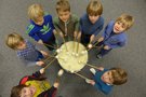 Kinder spielen auf einer Trommel. Foto: Stadt Oldenburg