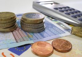 Geld und Taschenrechner liegen auf einem Tisch. Foto: Claudia Hautumm/Pixelio