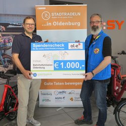 Michael Ottens, Inhaber ol-e urban:mobil, überreicht den Scheck für das Erreichen des zweiten Etappenziels an Stephan Mickoleit, Mitarbeiter Bahnhofsmission Oldenburg. Foto: Stadt Oldenburg Michael Ottens, Inhaber ol-e urban:mobil, überreicht den Scheck für das Erreichen des zweiten Etappenziels an Stephan Mickoleit, Mitarbeiter Bahnhofsmission Oldenburg. Foto: Stadt Oldenburg