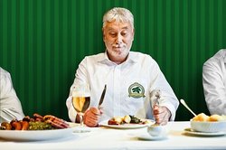 Mann mit Grünkohlgericht auf dem Teller. Foto: Verena Brandt/OTM