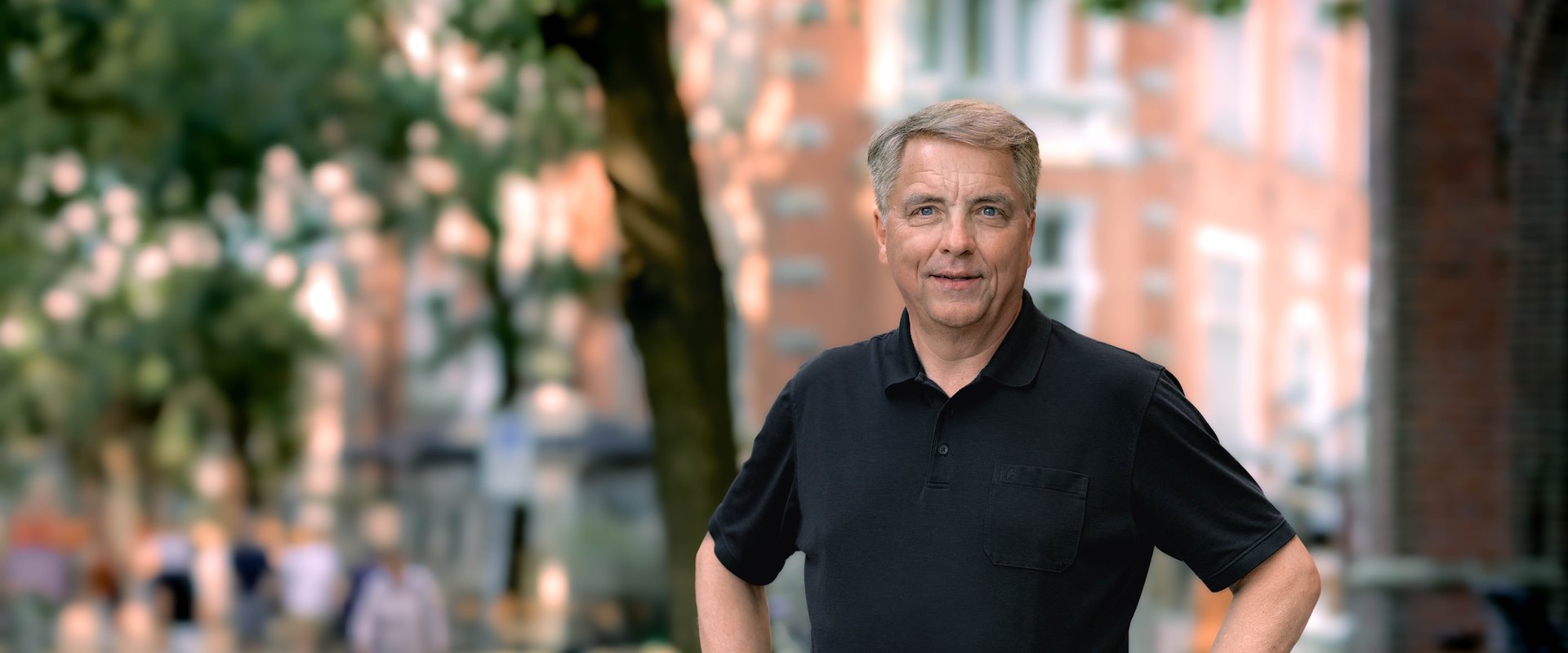Oberbürgermeister Jürgen Krogmann stehend mit Poloshirt in der Innenstadt.