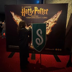 Eine Besucherin der Freizeitstätte steht mit einem Zauberstab vor einem Harry Potter Werbeschild. Foto: Stadt Oldenburg Eine Besucherin steht mit einem Zauberstab vor einem Harry Potter Werbeschild. Foto: Stadt Oldenburg