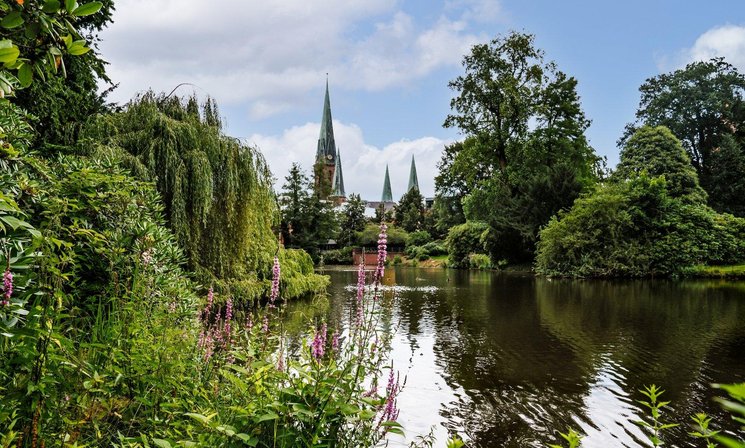 Teich im Schlossgarten mit der Lambertikirche im Hintergrund. Foto: Mittwollen und Gradetchliev