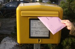 Briefwahlumschlag wird in Postkasten geworfen. Fotos: Norbert Staudt/Pixelio