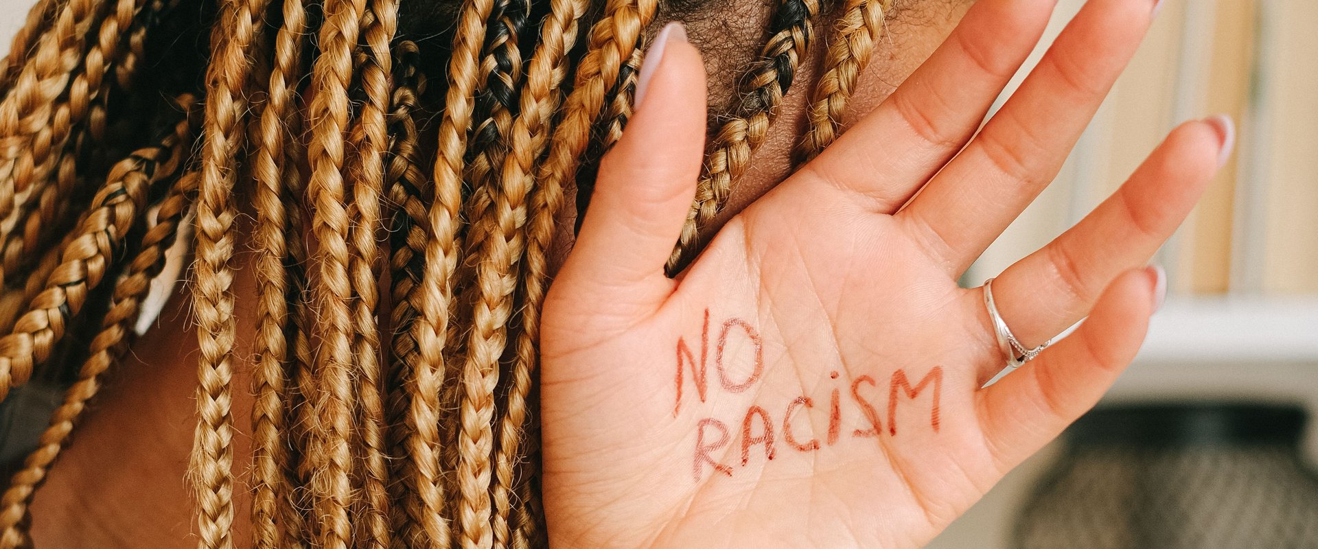 Hand mit Schriftzug "No Racism". Foto: Ivan S./Pexels