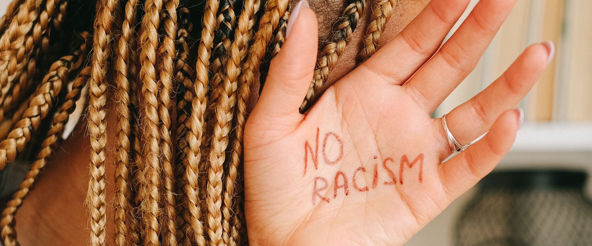 Hand mit Schriftzug "No Racism". Foto: Ivan S./Pexels
