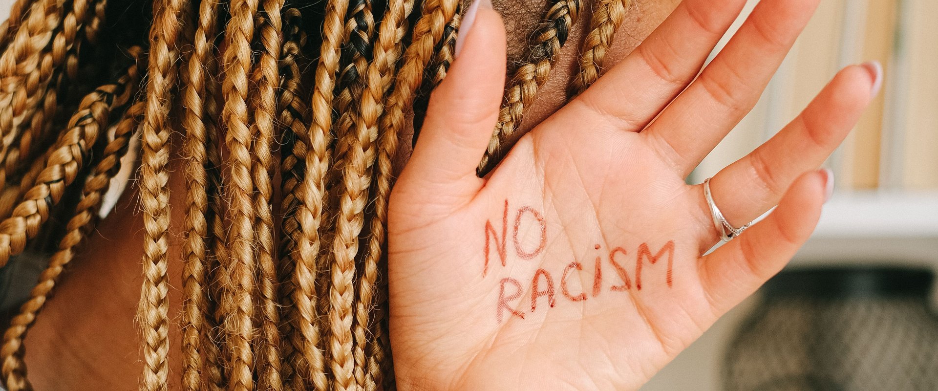 Hand mit Schriftzug "No Racism". Foto: Ivan S./Pexels