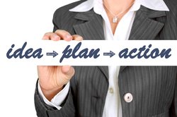 Geschäftsfrau hält Schild mit der Aufschrift „idea, plan, action“. Foto: geralt/pixabay