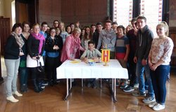 Schülerinnen und Schüler aus Cholet mit ihren Lehrerinnen und Bürgermeisterin Germaid Eilers-Dörfler stehen um den Tisch, auf dem das Gästebuch liegt. Foto: Stadt Oldenburg