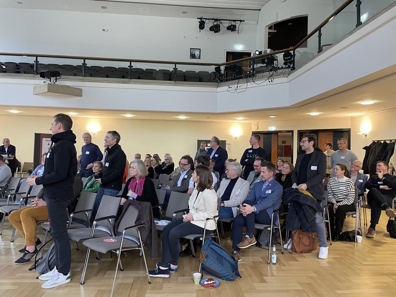 Bei der Publikumsabfrage stehen Vertreterinnen und Vertreter aus Dienstleistungsunternehmen auf. Foto: Stadt Oldenburg