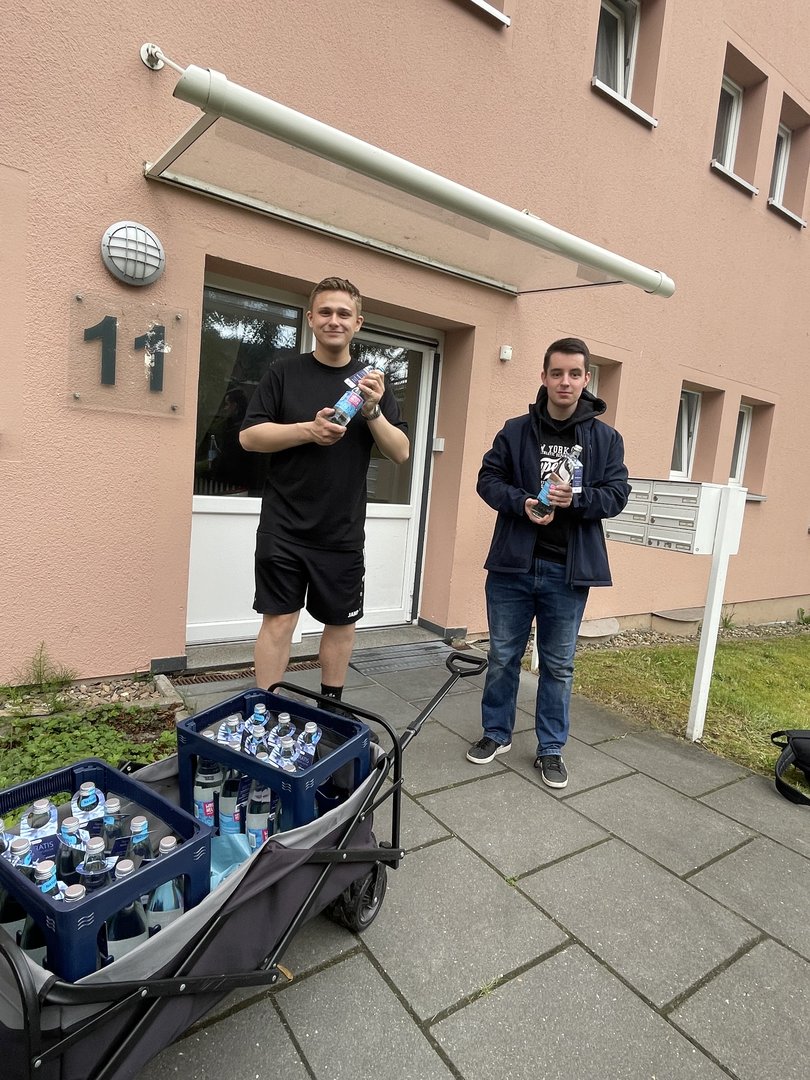 Zwei Schüler der IGS Kreyenbrück verteilen Mineralwasserflaschen in GSG Mietshäusern. Foto: IGS Kreyenbrück